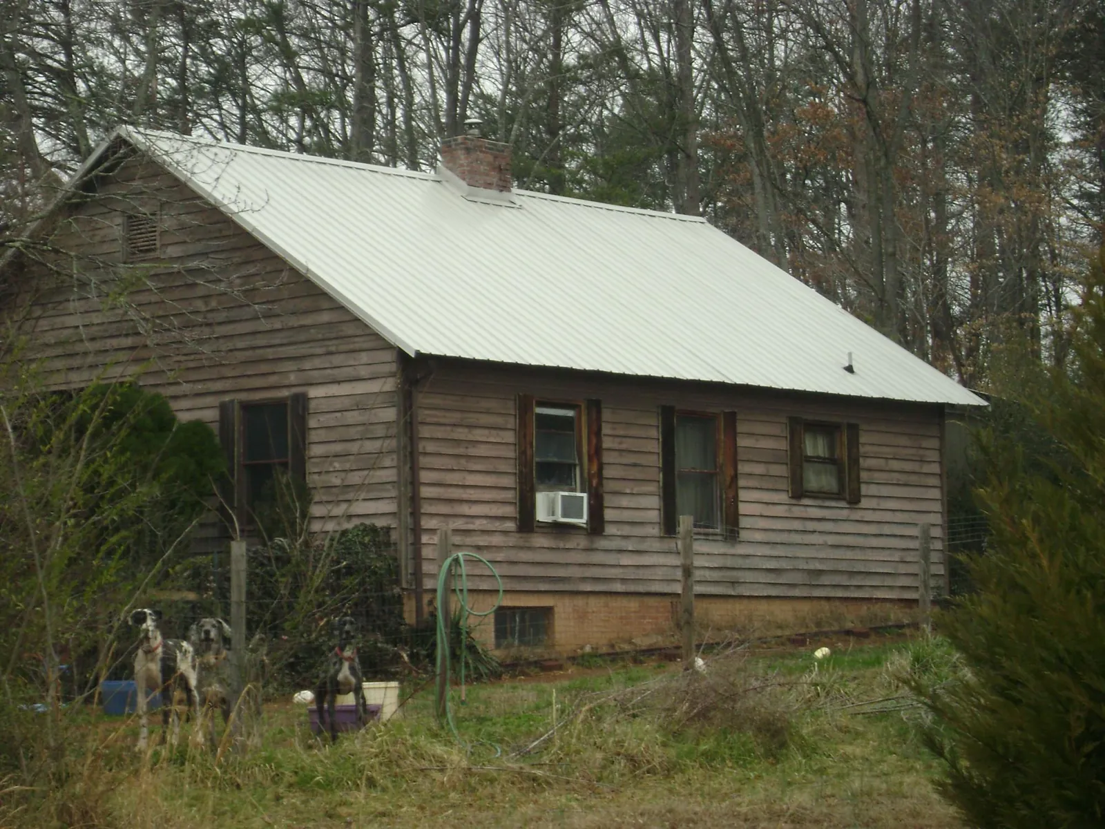 White metal roof on an old wood sided farmhouse, from a Asphalt Shingle Roof Repair job in Cushing